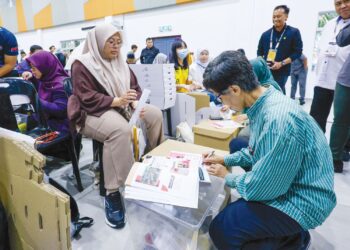 PETUGAS Suruhanjaya Pilihan Raya (SPR), sedang membuat persiapan menjelang hari mengundi Pilihan Raya Negeri Johor ke-16, di Dewan Serbaguna Permas, Pontian, semalam. – UTUSAN/SHIDDIEQIIN ZON