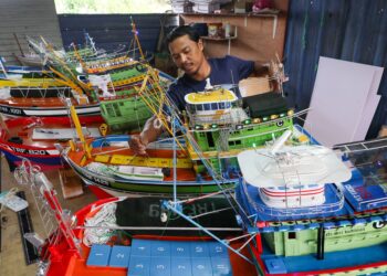MOHD. Asrul Gulam Mohd memasang komponen replika bot fiber mini yang dihasilkannya di Kampung Surau Panjang, Kuala Terengganu, Terengganu. – UTUSAN/PUQTRA HAIRRY