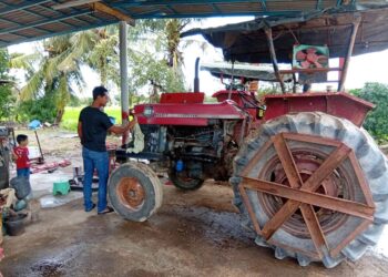 MOHAMAD Hafiz Azizan menyelenggara salah sebuah jentera membajak yang diusahakan bapanya, Azizan Osman ketika ditemui di Kampung Sungai Gelam, Merbok, Kedah, semalam.