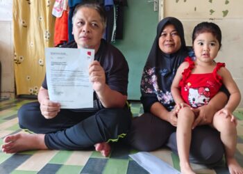 MOHD. Zahidat Ishak (kiri) menunjukkan surat penamatan kerja disamping Hamidah ketika ditemui di rumah pekerja Pusat Penyelidikan Pertanian Tun Razak, Tekam di Jerantut, Pahang. – UTUSAN/HARIS FADILAH AHMAD