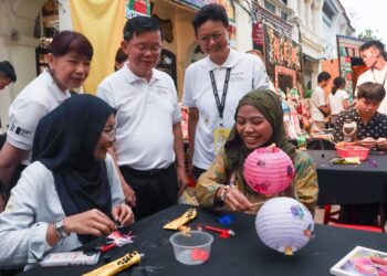 CHOW Kon Yeow (berdiri, dua dari kiri) melihat pengunjung diberikan peluang untuk menghasilkan sendiri tanglung ketika hadir meninjau Festival Jalanan sempena Perayaan Warisan George Town 2026 di Pulau Pinang, semalam.-UTUSAN/DANIAL SAAD