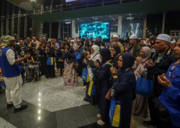 SEBAHAGIAN jemaah umrah mengaminkan bacaan doa sebelum berangkat ke Tanah Suci pada majlis pelepasan kumpulan jemaah umrah ke Tanah Suci di KLIA Terminal 1. - UTUSAN/FAISOL MUSTAFA