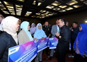 PENGERUSI MARA, Datuk Dr. Asyraf Wajdi Dusuki beramah mesra dengan penerima Pembiayaan PRIN sempena Himpunan Usahawan Johor di Pusat Konvensyen Antarabangsa Persada, Johor Bahru disini. UTUSAN/RAJA JAAFAR ALI