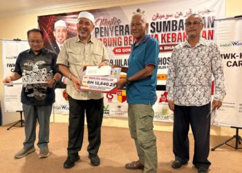 DR. Izani Husin (dua dari kiri) menyampaikan sumbangan bantuan kepada mangsa kebakaran pada majlis di Kampung Badang, Kota Bharu, Kelantan. – UTUSAN/ ROSLIZA MOHAMED