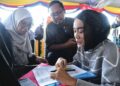 SITI Nur Amira Fauzi (kanan) dibantu keluarganya semasa mendaftarkan diri pada Program Latihan PLKN 3.0 di Kem 504 AW, Bukit Keteri, Perlis semalam. – MINGGUAN/IZLIZAN OTHMAN