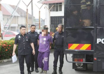 SUSPEK diiringi polis semasa menghadiri prosiding reman di Mahkamah Tumpat, Kelantan hari ini-UTUSAN/ROHANA ISMAIL.