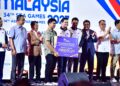 AIMAN Amri (tengah) menerima cek bernilai RM8000 daripada Menteri Belia dan Sukan, Dr Mohamed Taufiq Johari pada Majlis peluncuran Logo, Maskot, dan Tema rasmi Sukan SEA ke-34 dan Sukan Para ASEAN ke-14 2027-IHSAN KBS