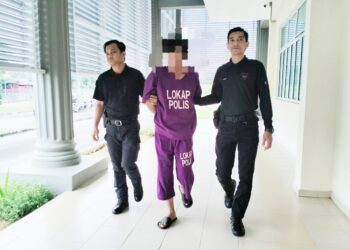 TERTUDUH dibawa oleh polis untuk prosiding perbicaraan di Mahkamah Seksyen Pasir Mas, Kelantan hari ini-UTUSAN/ROHANA ISMAIL.