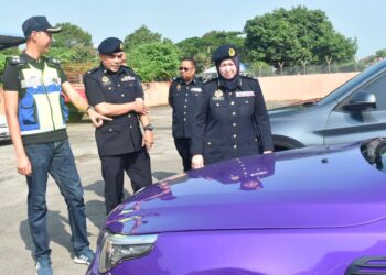 NORAINI Mohd Nawi (kanan) meninjau kenderaan yang disita di Depoh JPJ, Kangar, Perlis hari ini.-UTUSAN/ASYRAF MUHAMMAD