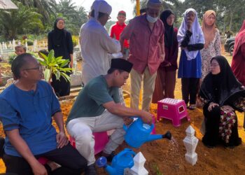 MOHD. FAAIZ (dua kiri) menyiram air mawar atas pusara anaknya, Muhammad Umar selepas selesai dikebumikan di Tanah Perkuburan Islam Taman Sri Lalang, Kluang hari ini.