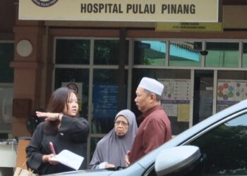 SALMAH Shamsudin (tengah) ketika hadir menuntut jenazah anaknya, Shahir Zainul di Jabatan Perubatan Forensik Hospital Pulau Pinang, hari ini. - UTUSAN/DANIAL SAAD