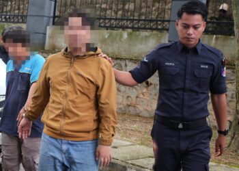 SEORANG lelaki yang juga aktivis (tengah, berbaju kuning) dibawa ke Mahkamah Majistret Seremban hari ini untuk tujuan permohonan reman bagi siasatan kes ugutan di media sosial.-UTUSAN/MOHD. SHAHJEHAN MAAMIN.