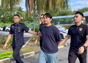 TAMIM Dahri Abdul Razak dikawal anggota polis ketika dibawa untuk pertuduhan di Mahkamah Majistret Langkawi, hari ini.