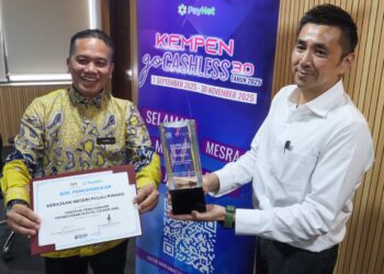 H’NG Mooi Lye (kanan) bersama Muhamad Husni Mahmud menunjukkan piala dan sijil Johan Anugerah Prestasi Penggunaan Pembayaran Digital Cemerlang bagi Program Kempen Cashless Boleh 5.0 yang diperolehi ketika sidang akhbar di George Town, Pulau Pinang hari ini.-UTUSAN/DANIAL SAAD