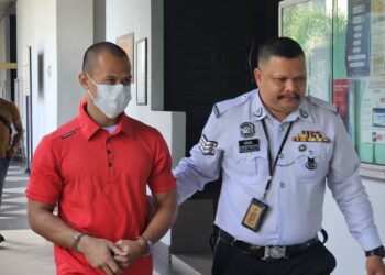 JAD Faid Arhan ketika diiringi anggota polis trafik selepas prosiding pengurusan kes melibatkan pertuduhan memandu di bawah pengaruh alkohol sehingga menyebabkan kecederaan dan kematian di Mahkamah Majistret, di sini hari ini.