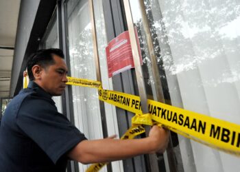 PENGUATKUASA MBIP menampal notis penutupan keatas premis Network School di Forest City, Iskandar Puteri disini. UTUSAN/RAJA JAAFAR ALI