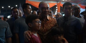 ANWAR Ibrahim menyantuni kanak-kanak pada Majlis Perasmian Program Santai Perantau Sempena 70 Tahun FELDA di Jalan Maktab, Kuala Lumpur hari ini. - UTUSAN/SYAKIR RADIN
