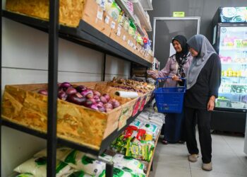 SITI Masita Sabyumin (kiri) dan adiknya, Siti Norliza memilih barangan yang dibeli dengan wang Sara di sebuah kedai di pekan Linggi dekat Port Dickson hari ini.UTUSAN/NAZARUDIN SHAHARI