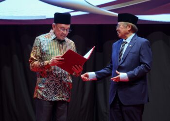 YANG Dipertua Pertubuhan Kebajikan Islam Malaysia (PERKIM), Tan Sri Abang Johari Tun Openg (kanan) menyerahkan Resolusi Konvensyen Wakaf Dakwah Antarabangsa 2026 kepada Perdana Menteri, Datuk Seri Anwar Ibrahim pada majlis penutup di Pusat Konvensyen Kuala Lumpur (KLCC).-UTUSAN/FARIZ RUSADIO