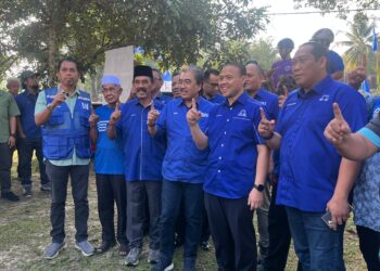 JOHARI Abdul Ghani (tengah) bergambar bersama calon BN bagi DUN Seri Menanti, Muhammad Sufian Maradzi (dua dari kanan) di Pusat Daerah Mengundi (PDM) Kampung Tengah Seri Menanti, Kuala Pilah hari ini
