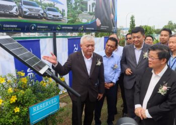 CHOW Kon Yeow (depan, kanan) mendengar penerangan daripada Ooi Heng Ee (kiri) mengenai projek pemasangan panel solar di kawasan parkir di Bayan Lepas, Pulau Pinang hari ini.-UTUSAN/DANIAL SAAD