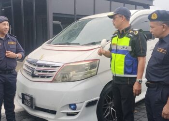 MOHAMMAD Yusoff Abustan (dua dari kanan) memeriksa sebuah kenderaan yang disita di JPJ Taiping, Perak.