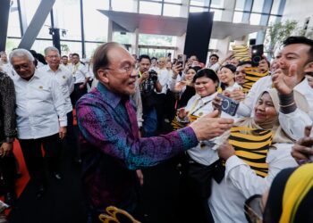 anwar Ibrahim beramah mesra kakitangan Maybank pada Majlis Pelancaran Ibu Pejabat Maybank baharu di Menara Merdeka Maybank, baru-baru ini. - UTUSAN/SHIDDIEQIIN ZON