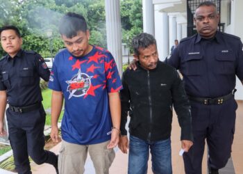 JUNAIDI (dua dari kanan) dan Irfansyah (dua dari kiri) diiringi anggota polis ketika dihadapkan ke Mahkamah Majistret Balik Pulau, Pulau Pinang hari ini atas dua pertuduhan iaitu mengedar dadah jenis methamphetamine dan cecair methamphetamine.-UTUSAN/DANIAL SAAD