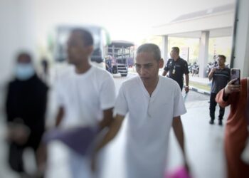 AMRAN Salleh (kanan) semasa dibawa polis untuk prosiding perbicaraan di Mahkamah Tinggi Kota Bharu, Kelantan. - UTUSAN/KAMARUL BISMI KAMARUZAMAN