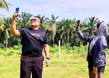PENDUDUK cuba mendapatkan capaian internet di kawasan lapang di kampung mereka di Tapah hari ini.