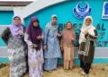 Mariam Nor atau Nenek Yam (dua, kanan) bersama ahli keluarga menunjukkan jari dicelup dakwat selepas membuang undi di SK Al-Ulum, Benut, Pontian. - UTUSAN/MUHAMMAD ZIKRI