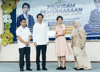 KAMIL Abdul Munim (dua dari kiri) menyampaikan penghargaan kepada satu daripada sekolah di bawah seliaan Pejabat Pendidikan Daerah (PPD) Kuala Kangsar di Padang Rengas, Perak hari ini. - UTUSAN/FADZIL ZAINOL