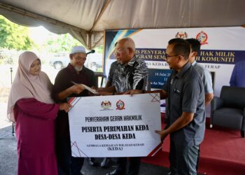 MAHDZIR Khalid menyampaikan geran hak milik kepada penerima pada Majlis Penyerahan Geran Hak Milik dan Program Semarak Kasih Komuniti Desa KEDA di Desa KEDA Semeliang, Kuala Nerang. - UTUSAN/ SHAHIR NOORDIN