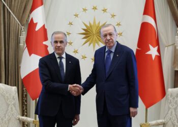 ERDOGAN berjabat tangan dengan Carney. - AFP