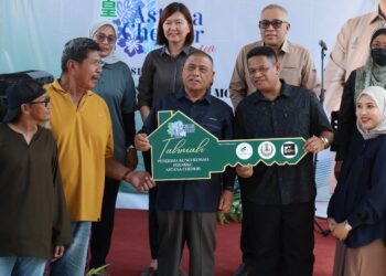SAARANI Mohamad (tengah) menyampaikan replika kunci kepada pembeli selepas menyempurnakan Majlis Perasmian Projek Perumahan Perakku Astana Chemor, Ipoh hari ini.