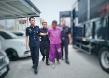 SUSPEK (tengah) diiringi anggota polis untuk prosiding mendapatkan perintah reman di Mahkamah Majistret Tumpat, Kelantan. - UTUSAN/ROHANA ISMAIL 