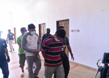 DUA lelaki (berbaju belang dan putih) mengaku bersalah memiliki kad pengenalan milik individu lain di Mahkamah Majistret Kuantan di Kuantan, Pahang.