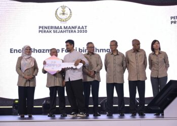 SAARANI Mohamad (dua dari kiri) menyerahkan replika kunci rumah Program Rumah Perakku Prihatin Yayasan Perak kepada penerima pada Pembentangan Laporan Kemajuan Tahun Keempat Perak Sejahtera 2030 di Ipoh hari ini.