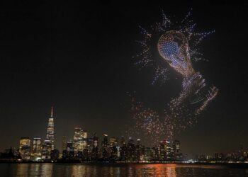 Pertunjukan dron membentuk replika trofi Piala Dunia menghiasi ruang udara Pelabuhan New York dengan latar belakang bangunan pencakar langit Lower Manhattan di Liberty State Park, Jersey City, New Jersey menjelang aksi final Piala Dunia 2026 antara Sepanyol dan Argentina, awal pagi esok. – AFP