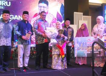 Syamsiah Zakaria menerima Anugerah Tokoh Guru JAIM daripada Ab. Rauf Yusoh pada Majlis Sambutan Hari Guru dan Anugerah Kecemerlangan Akademik Jabatan Agama Islam Melaka (JAIM), di Banda Hilir semalam. -UTUSAN/AMRAN MULUP