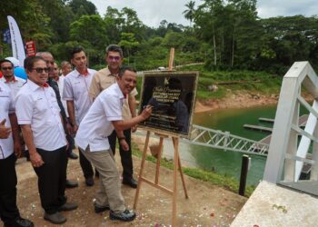 ROZI Mamat (kanan) menandatangani plag sebagai gimik Penyerahan Projek Membina dan Menyiapkan Kerja-Kerja Pengukuhan Tebing, Tambatan Rumah Bot, Tandas serta Kemudahan Berkaitan di Pengkalan Utama,di Jeti Tambatan Bot Pengkalan Utama, Tasik Kenyir, Hulu Terengganu, Terengganu.  - UTUSAN/PUQTRA HAIRRY