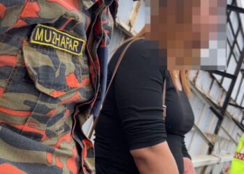 ANGGOTA bomba memujuk lelaki berpakaian wanita yang cuba terjun dari jejambat di Jalan Bercham, Ipoh hari ini.