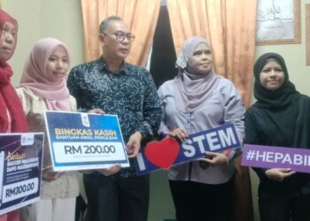 MOHD. Zamri Ibrahim (tengah) menyampaikan Bantuan Awal Pengajian dan Baucar Makanan kepada Nurul Amira Abdul Hamid (dua dari kiri) di Parit Jawa, Bagan Serai hari ini. - UTUSANWAT KAMAL ABAS