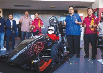 AHMAD Farhan Mohd. Sadullah (tiga dari kanan) bergambar di samping kereta Lumba Putra 2 yang telah dilancarkan di Serdang baru-baru ini bagi menyertai Perlumbaan Formula SAE Jepun 2026. – utusan/ MUHAMAD IQBAL ROSLI