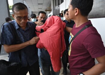 WARDEN (tengah) yang didakwa memukul banduan hingga menyebabkan kecederaan di Penjara Taiping pada Januari tahun lalu ketika pertuduhan di Mahkamah Majistret Taiping hari ini.