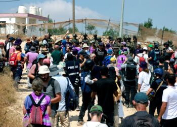 AKTIVIS mengadakan bantahan terhadap tindakan peneroka Israel mengepung rumah keluarga Palestin di kampung Qusra di selatan bandar Nablus, Tebing Barat.-AFP 