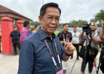 JALALUDDIN Alias menunjukkan jari telunjukkan yang dicalit dakwat selepas selesai mengundi di Sekolah Kebangsaan (SK) Putra, Simpang Durian, Jelebu, hari ini.