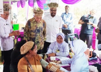 AHMAD Zahid Hamidi melihat seorang penduduk masyarakat Orang Asli menjalani pemeriksaan kesihatan di Kampung Orang Asli Air Banun dekat Gerik, Perak, hari ini.- UTUSAN/FADZIL ZAINOL