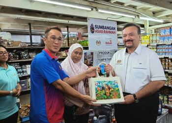 AMIR Hamzah Azizan menerima cenderamata daripada pengusaha tempatan berupa produk keluaran negeri Sabah. - UTUSAN/NASRAWATI SYARIFUDDIN