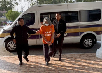 SUSPEK berusia 60-an diiringi pegawai SPRM bagi mendapatkan perintah tahanan reman di Mahkamah Majistret Ayer Keroh, hari ini.